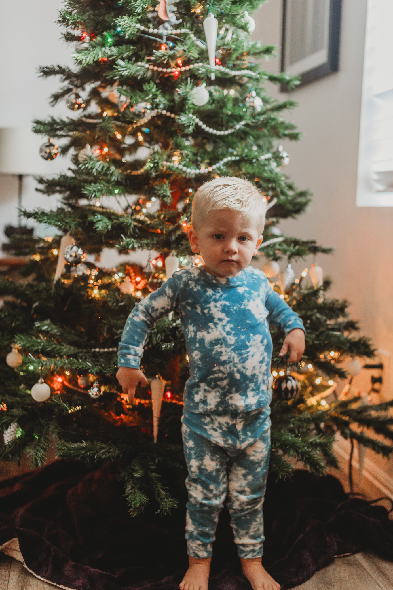 boy standing in front of christmas tree